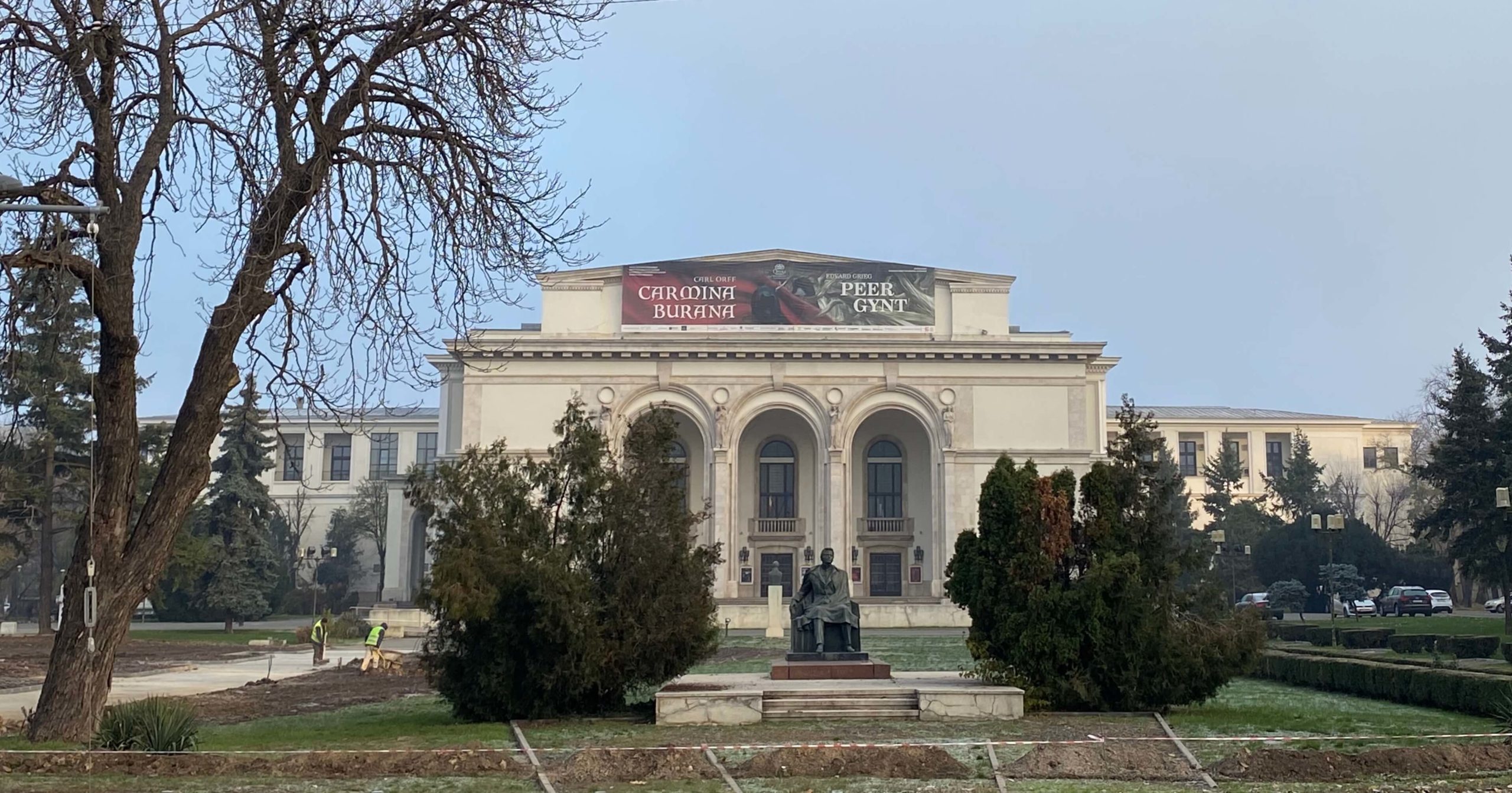 Opera Națională București și statuia din parcul Operei cu marele muzician George Enescu